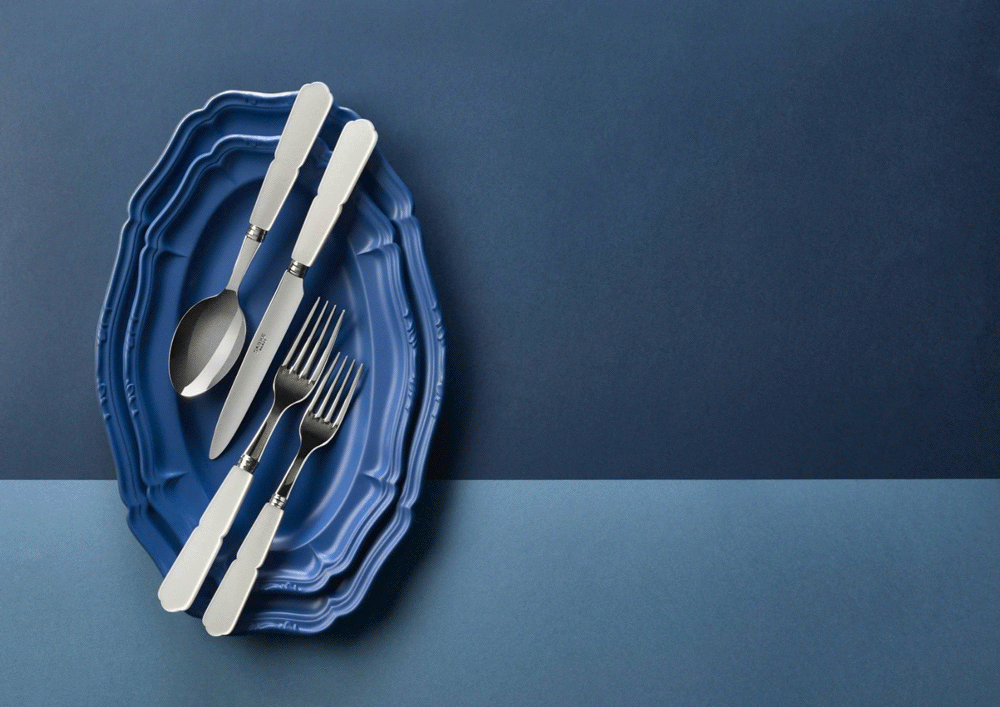 Sabre cutlery with white handles on a blue scalloped plate