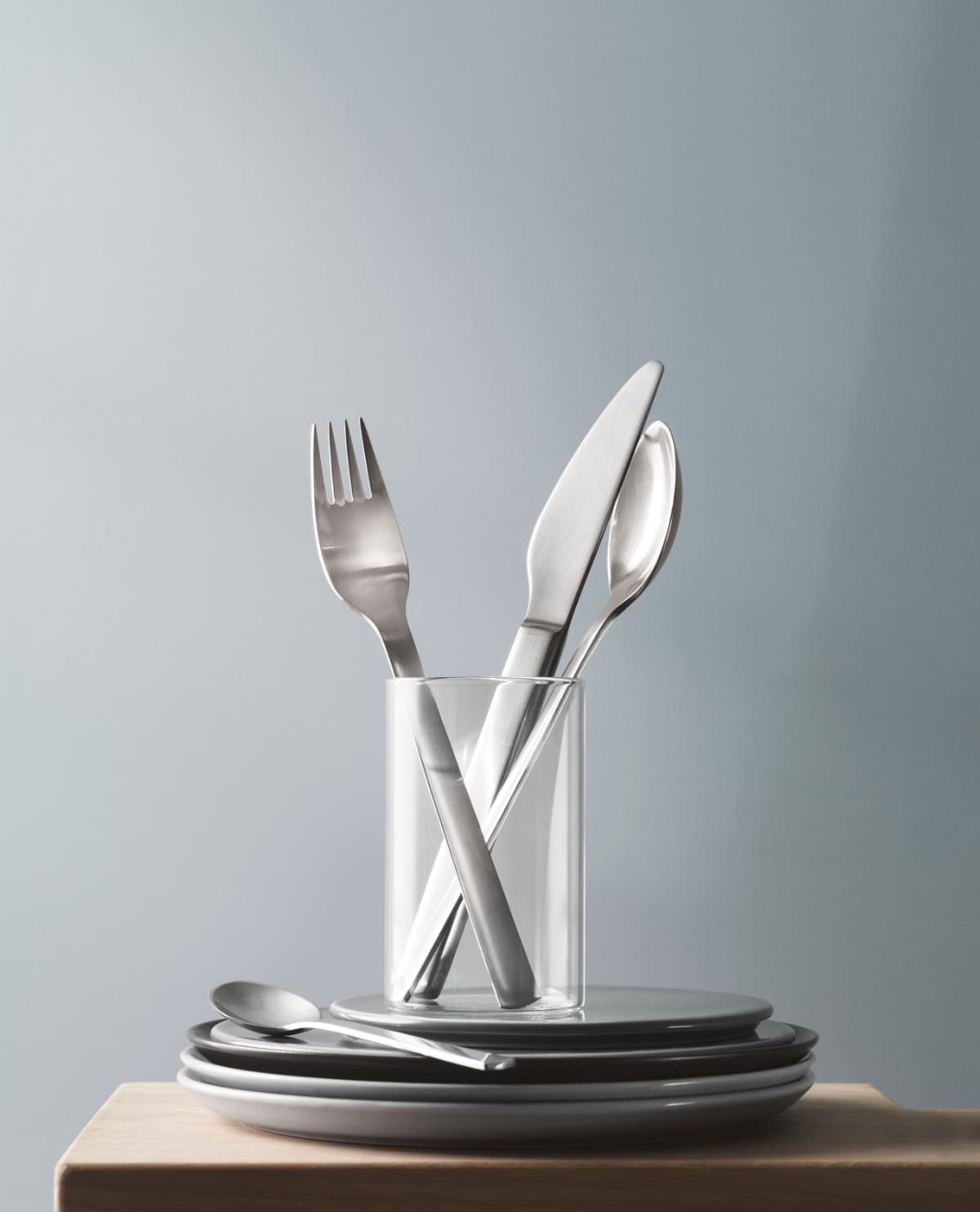 Georg Jensen cutlery in a glass on a stack of plates