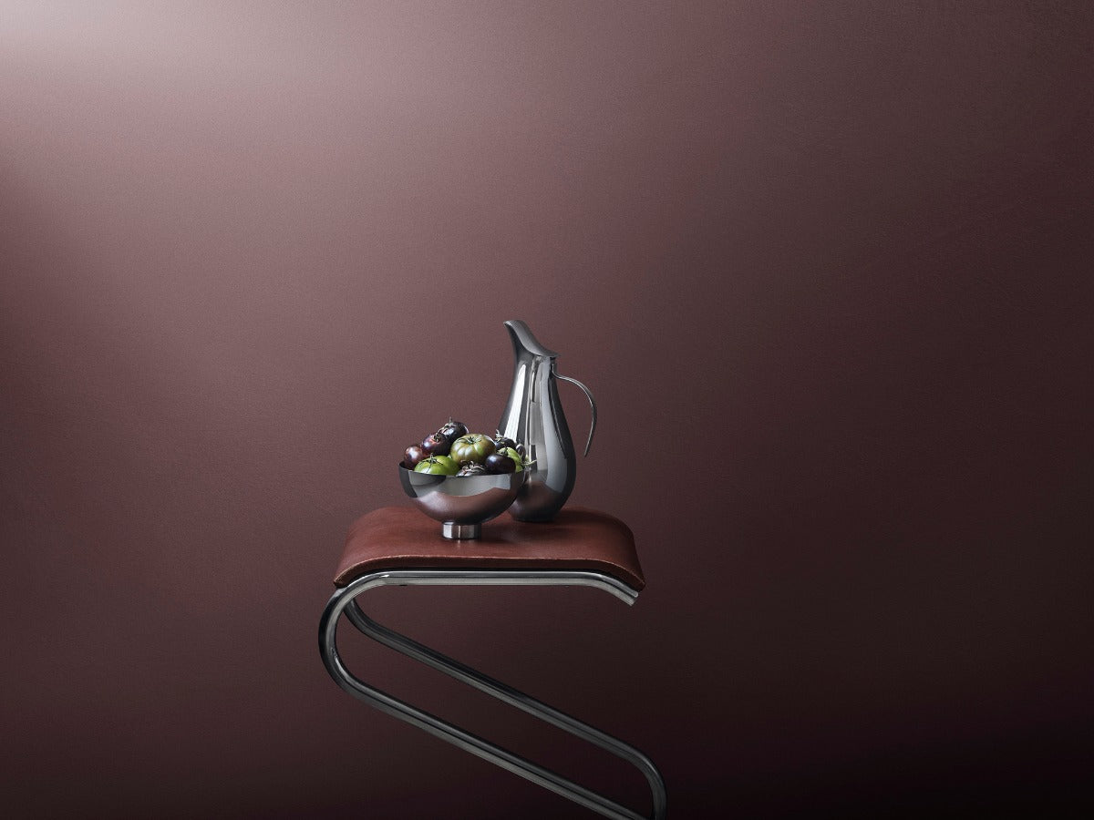 Georg Jensen stainless steel pitcher and bowl on a curved stool