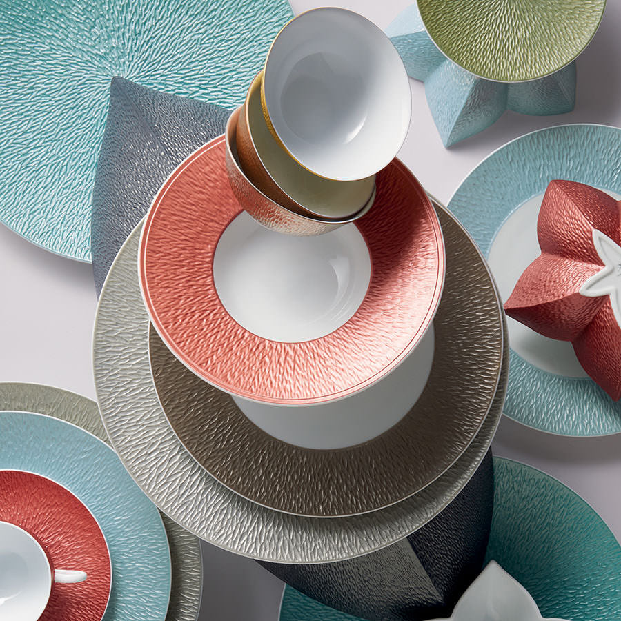 Stacked Raynaud porcelain plates and bowls in coral, grey and teal