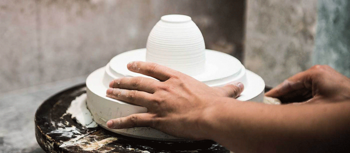 Craftsman finishing J.L. Coquet porcelain by hand