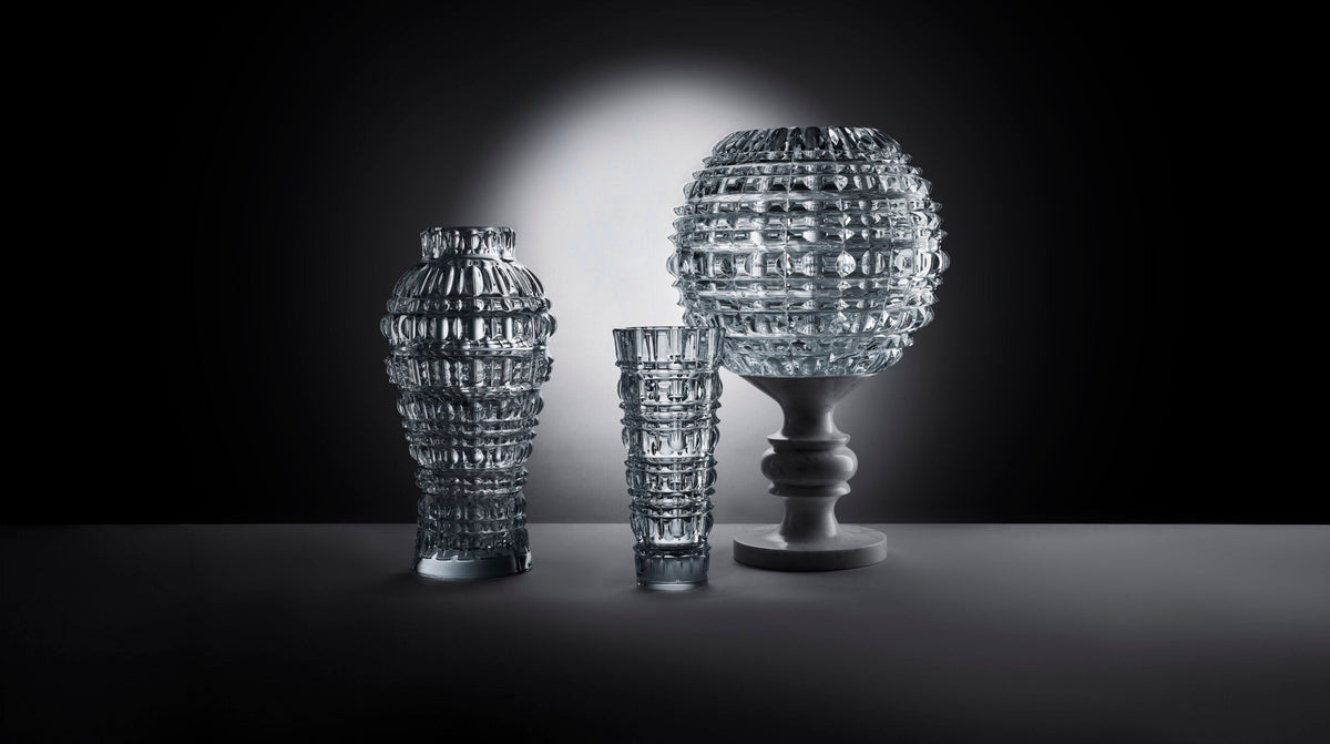 Marcel Wanders' crystal for Baccarat: faceted vases and a tumbler under a spotlight on a dark stage