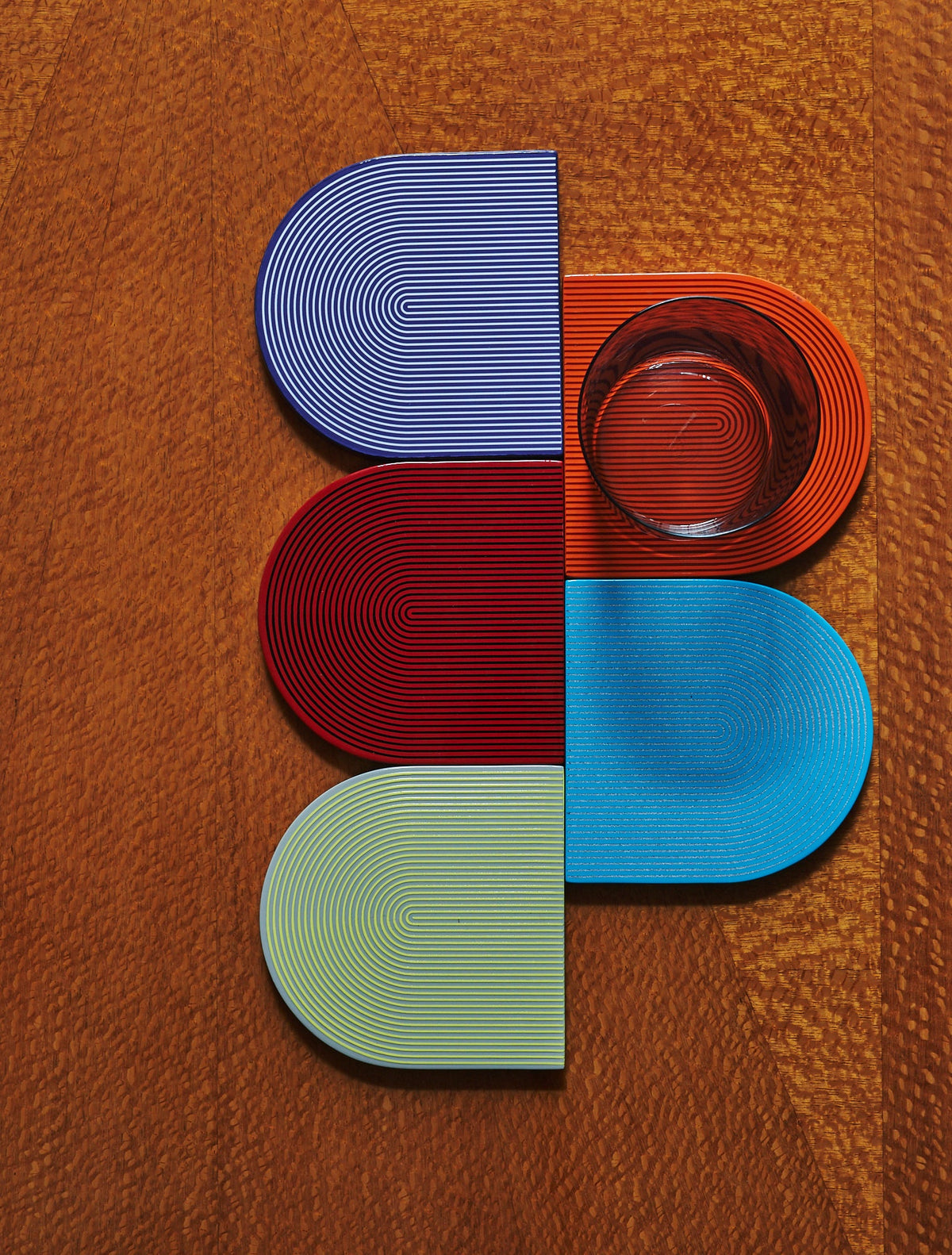 Von Gern Home coasters in blue, red, burgundy, turquoise and green with a glass, on a wooden table