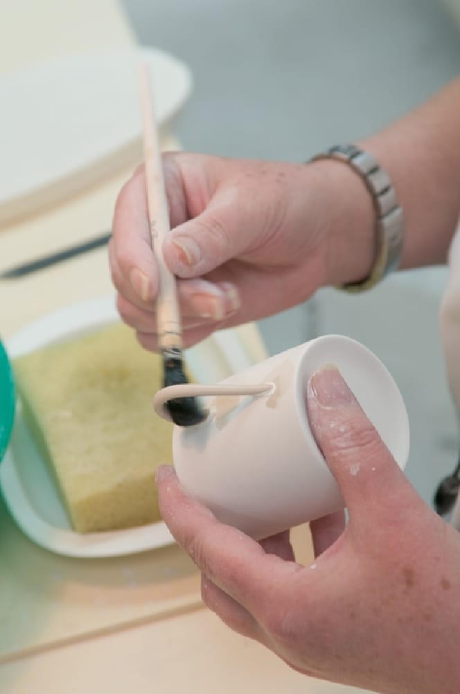 Seignolles artisan painting a porcelain cup by hand