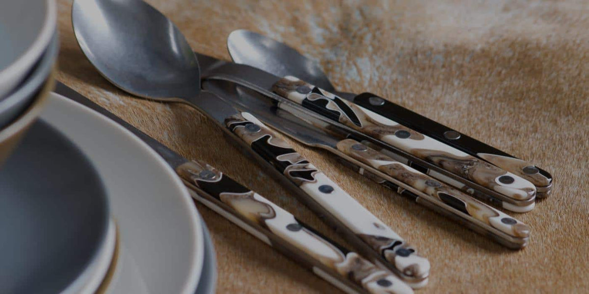 Sabre cutlery with marbled handles beside grey plates