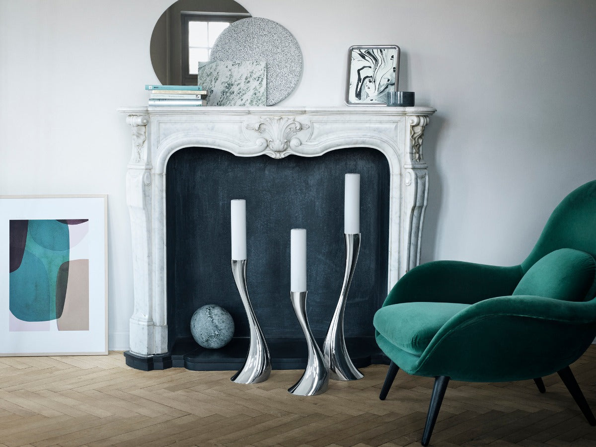 Sculptural Georg Jensen candleholders in a marble fireplace