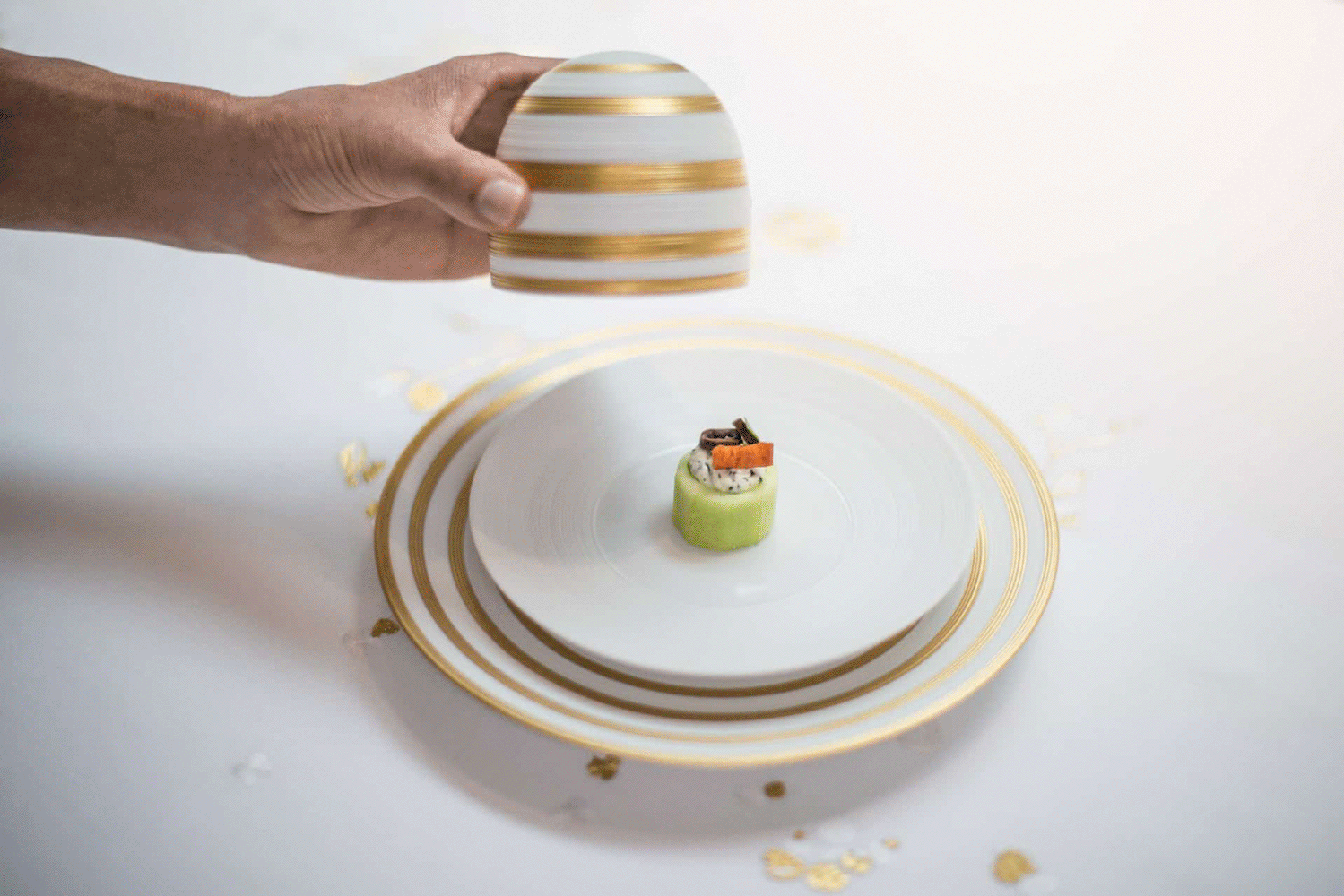 J.L. Coquet plate with gold bands and a gold-striped cloche
