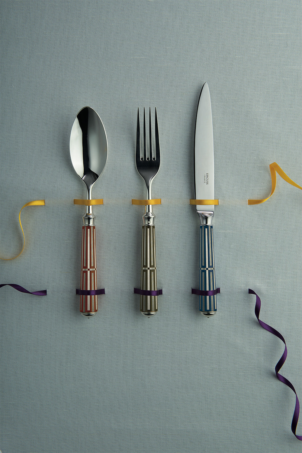 Ercuis cutlery with striped coloured handles tied with ribbon